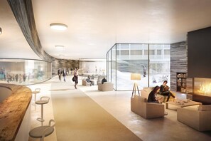 A modern lobby with a curved wooden reception desk, seating areas, and a fireplace. - Apartment in Éclose with Mountain Views (Huez)