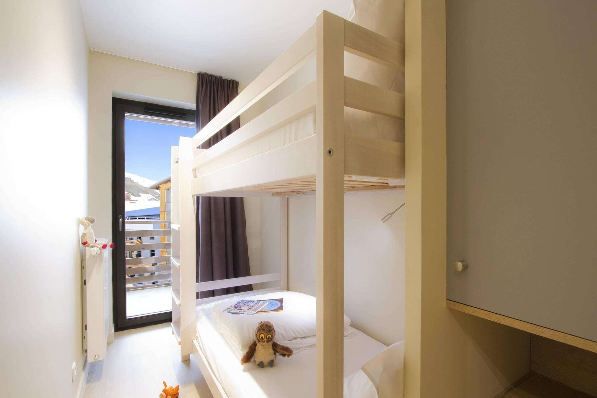 A bunk bed room with a view of a snowy landscape.
