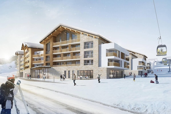A modern ski resort building with multiple balconies and a ski lift.