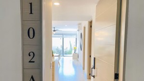 A modern hallway with a number sign indicating room 102A. - Unbeatable location 2BD 2BTH Walking distance to Medano... (Cabo San Lucas)
