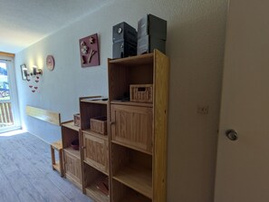 Een kamer met een houten plankenwand, een klein tafeltje en een raam met uitzicht.