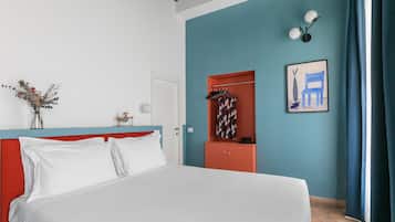 Un dormitorio con cama, armario, puerta y una pared con un cuadro.