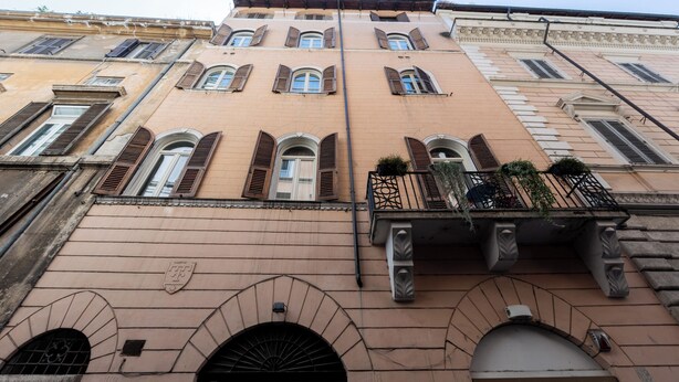 Fachada d'un edifici amb diverses finestres, un balcó i un rètol de 'Carrefour express'.