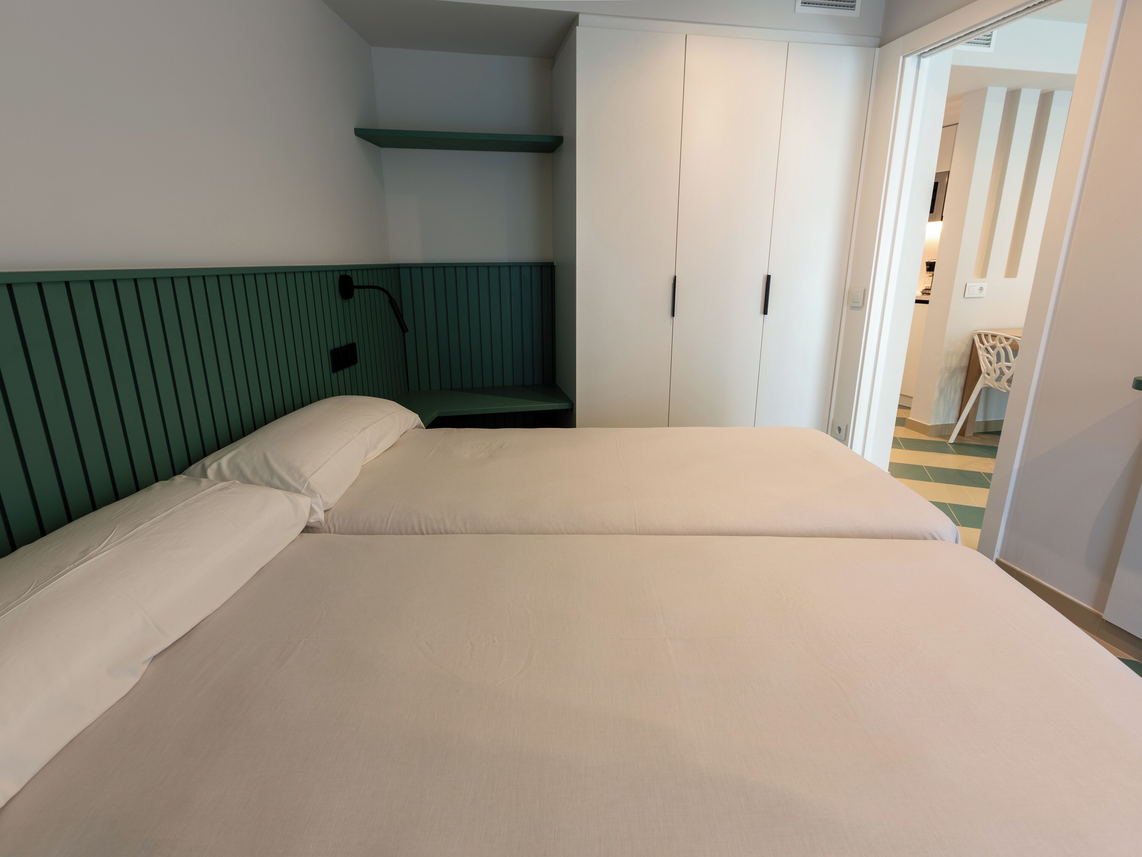 Une chambre à coucher comprenant un lit, une table de chevet, une armoire et une chaise.
