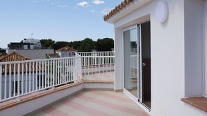 A balcony with a white railing, a glass door, and a tiled floor. - SUNWAY ATLANTA (Sitges)