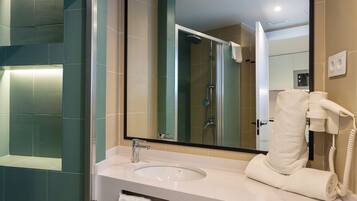 A modern bathroom with a large mirror, a sink, and a towel rack.