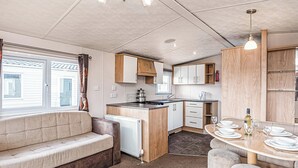 Ein kompaktes Wohnmobil-Interieur mit Küchenzeile, Essbereich und Sitzgelegenheiten.