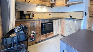 Eine Küche mit Holzausstattung, einem Backofen und einer Kaffeemaschine.