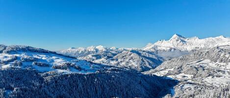 A snow-covered mountainous landscape with a small settlement and buildings.