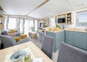 A compact living space with a kitchenette, dining area, and seating.