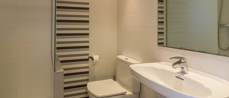 A bathroom with a toilet, sink, and shower.