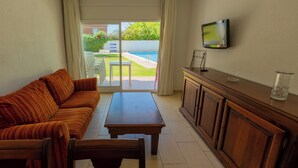 A living room with a sofa, coffee table, and TV. - SUNWAY SAN JORGE (Sitges)