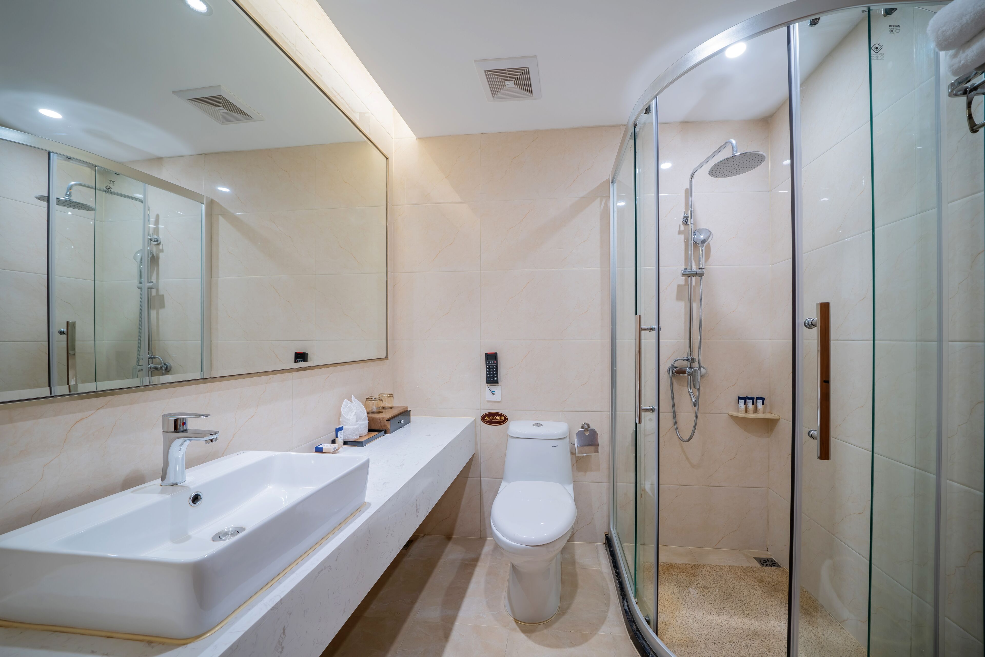 A modern bathroom with a glass-enclosed shower, a white sink, and a toilet.