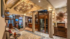 A spacious lobby with a patterned floor, a bar area, and a seating area with a table and chairs. - Santa Marta Suites (Milan)