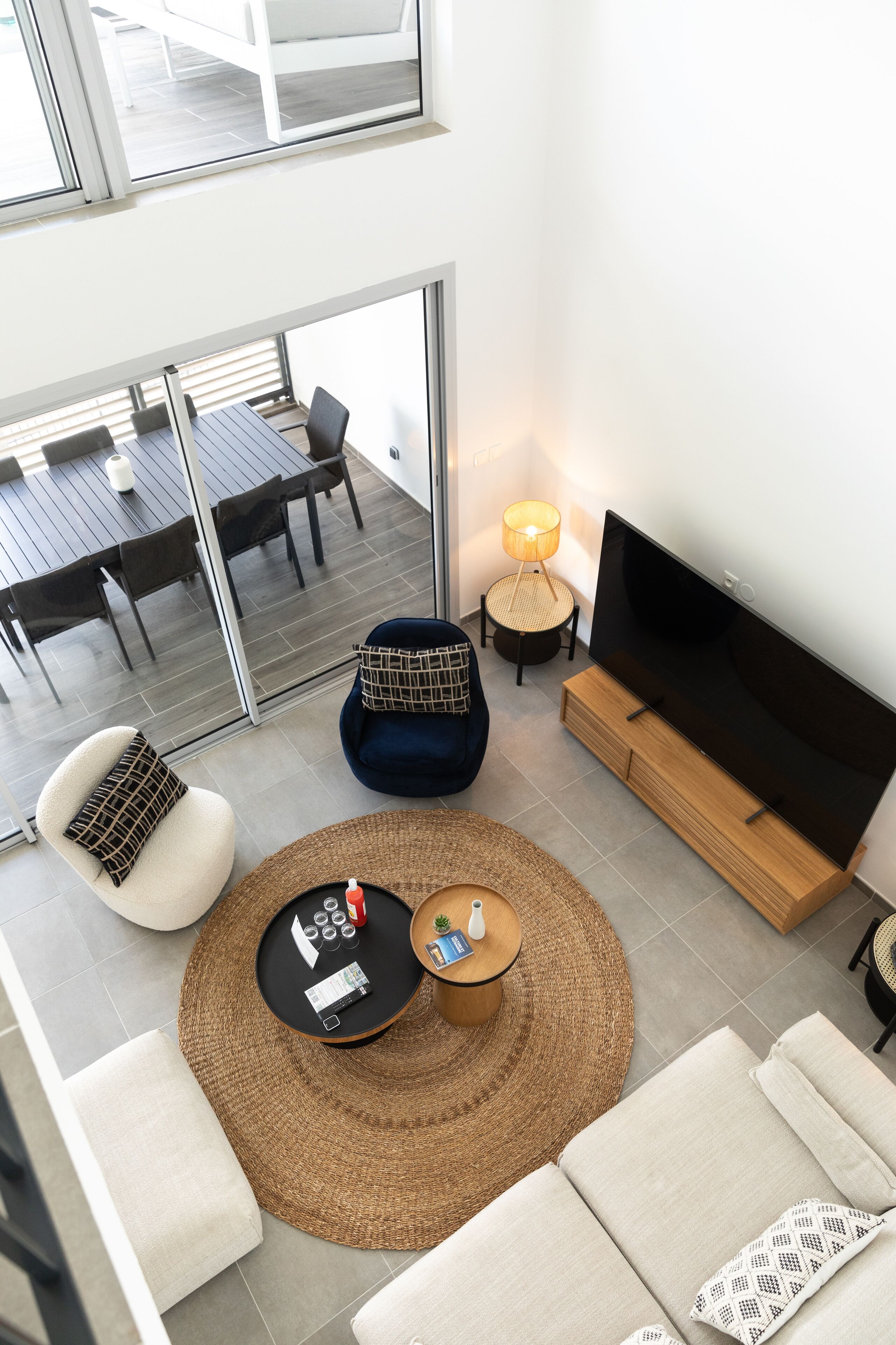 Un salon moderne comprenant un canapé, une table basse, un téléviseur et un coin repas avec une table et des chaises.