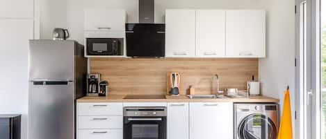 Une cuisine moderne dotée d’appareils électroménagers en acier inoxydable, de plans de travail en bois et d’un four encastré.