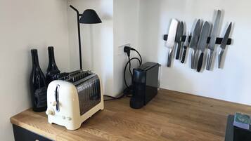 Une cuisine avec un plan de travail en bois, un grille-pain, une lampe et un porte-couteaux.