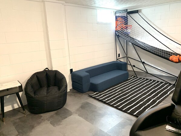 A room with a bed, a bean bag chair, a blue sofa, and a basketball hoop. - Modern 3 bd next to playground, trials and park (Westerville)