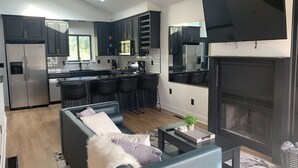 Una cucina moderna con mobili scuri, un'isola centrale e un piano cottura integrato.