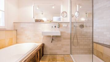 A modern bathroom with a bathtub, a sink, and a glass shower enclosure.