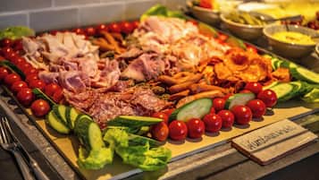 Un bufé con diversas carnes, verduras y un cartel que dice