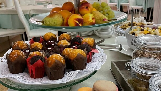 Un buffet proposant une variété de plats, notamment des fruits, des pâtisseries et des macarons.
