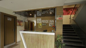 A reception desk with a wooden finish and a sign for 'Pride Inn'. - HOTEL PRIDE INN (Bhopal)