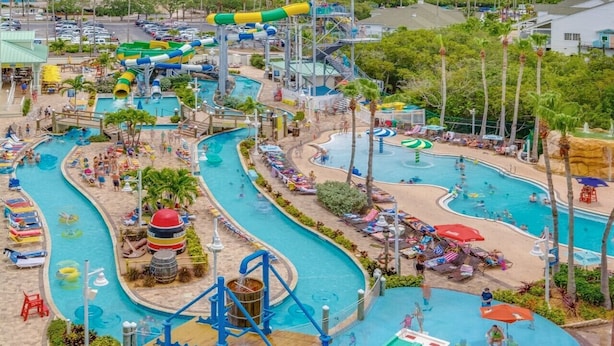 Un parque acuático con varias piscinas, toboganes y un gran tobogán central.