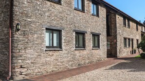 A stone building with multiple windows and a brick pathway leading to it. - Primrose at Stancombe Manor, Nr Kingsbridge (Kingsbridge)