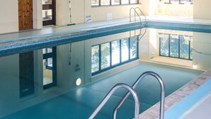A swimming pool with clear blue water, metal handrails, and a tiled floor. - Primrose at Stancombe Manor, Nr Kingsbridge (Kingsbridge)