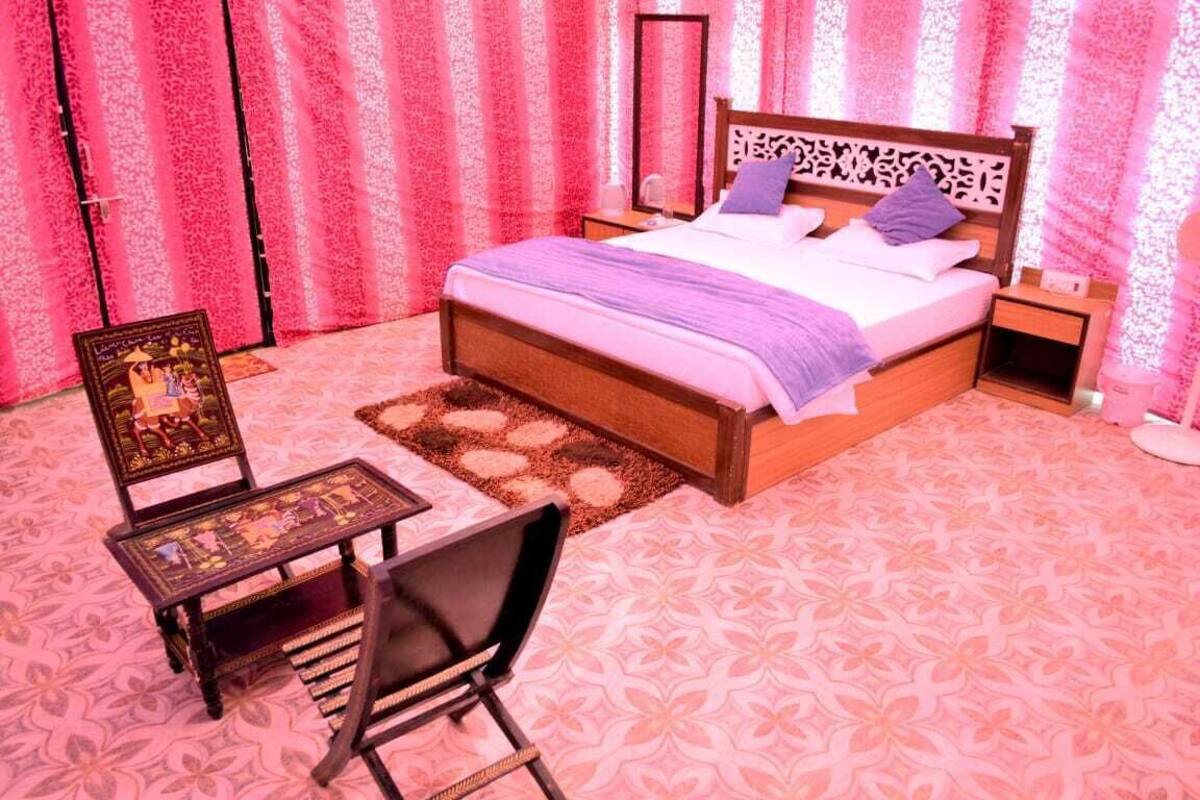Ein Schlafzimmer mit einem großen Bett, einem Nachttisch, einem Sessel und einem kleinen Tisch.