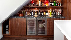 A kitchen with wooden cabinets, a marble countertop, and a built-in wine rack. - Hotel Grand View (Kathmandu)