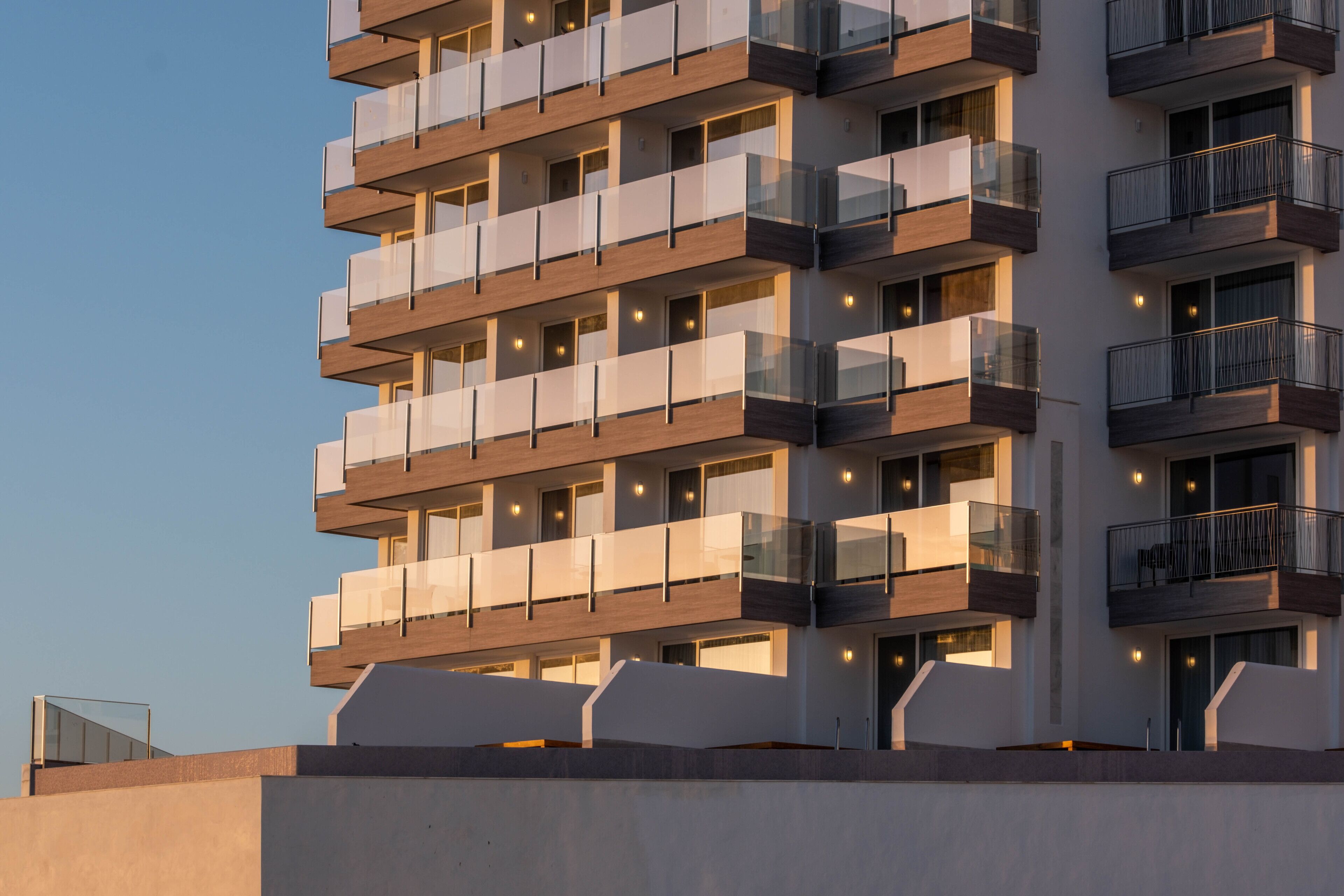 Un hotel de varios pisos con balcones, ventanas amplias y un diseño arquitectónico moderno.