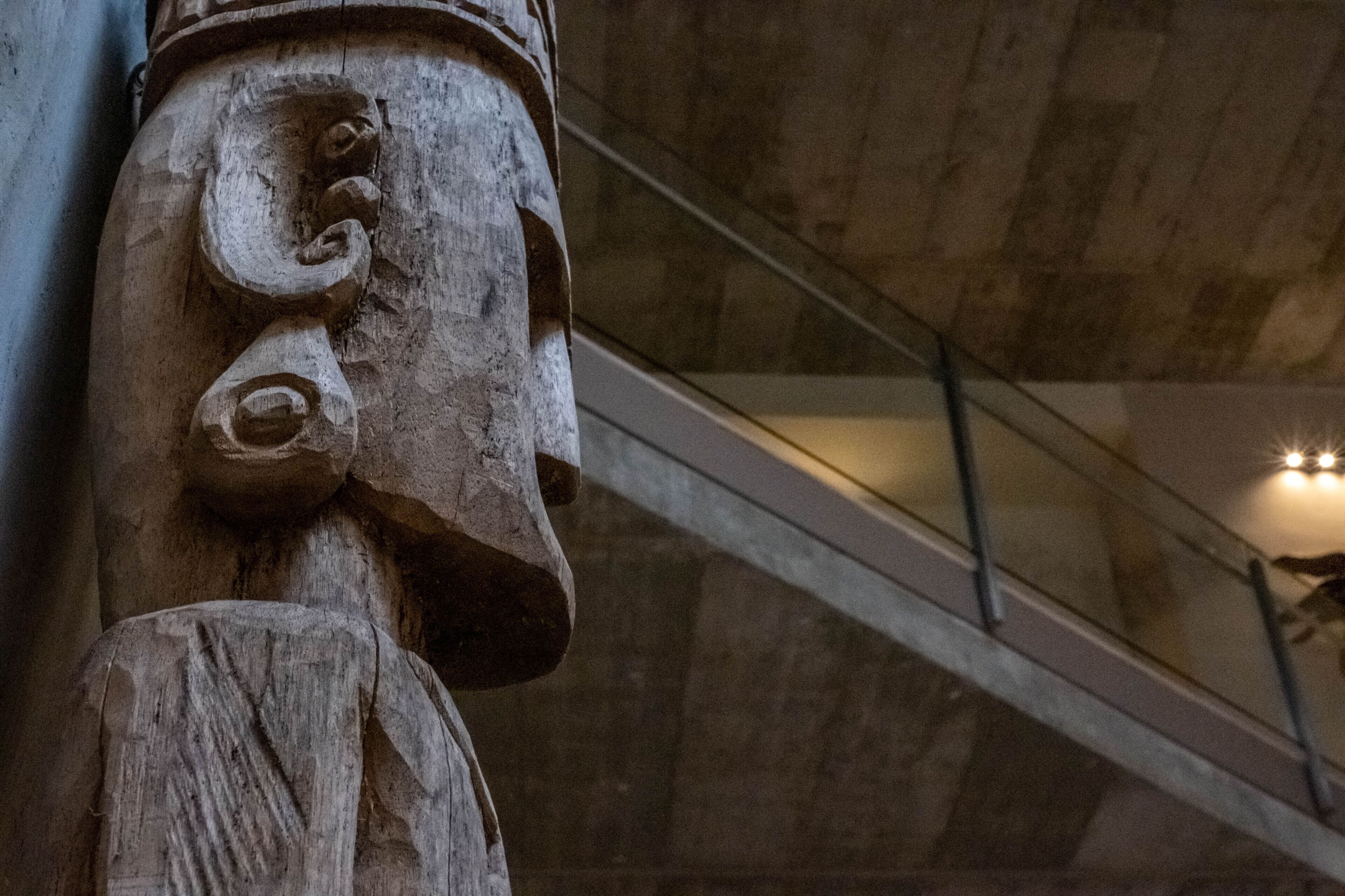 A close-up of a carved wooden sculpture with a rough texture and visible grain patterns.