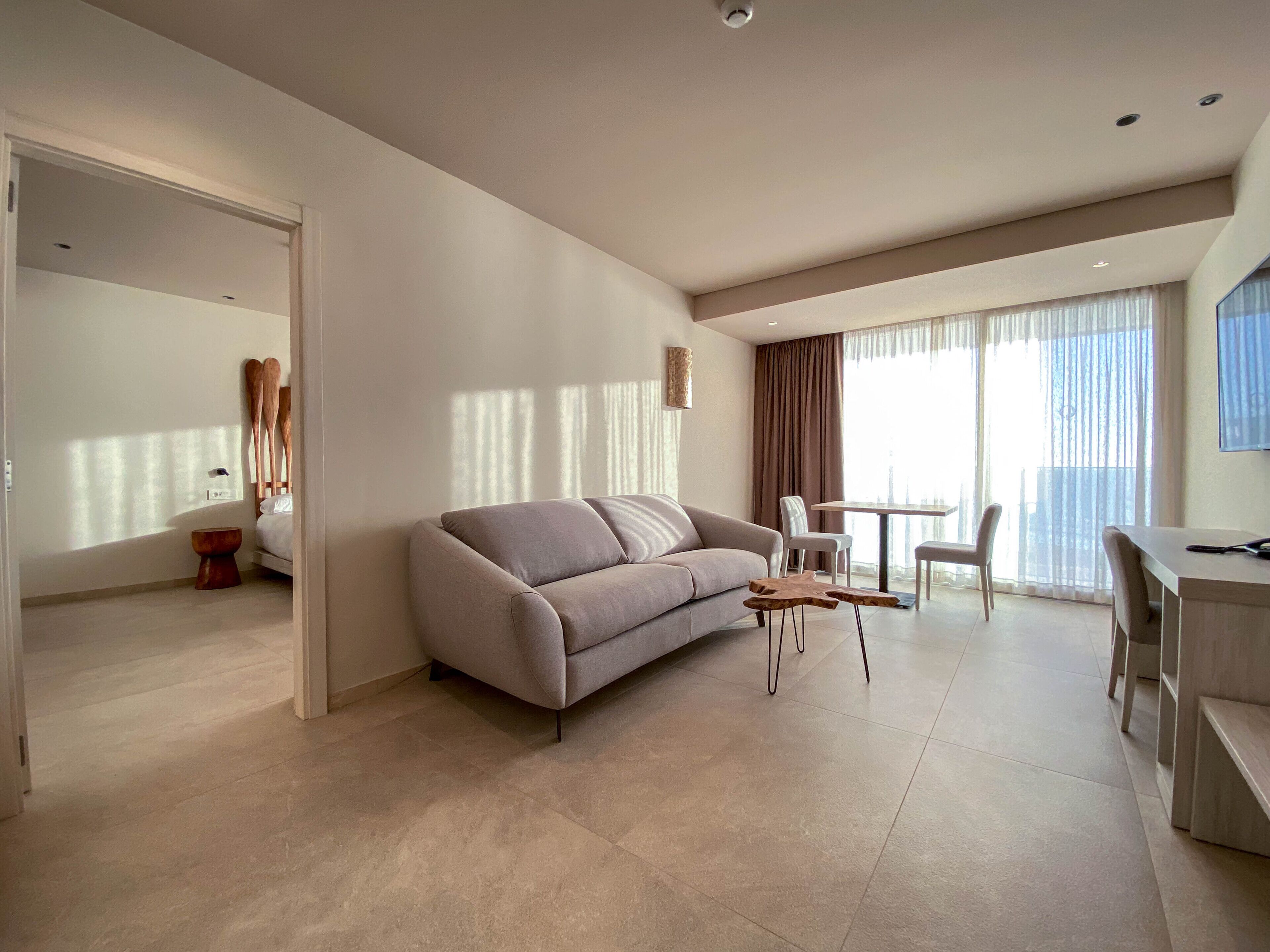 Una sala de estar moderna con un sofá, una mesa de centro y un comedor con sillas y una mesa.