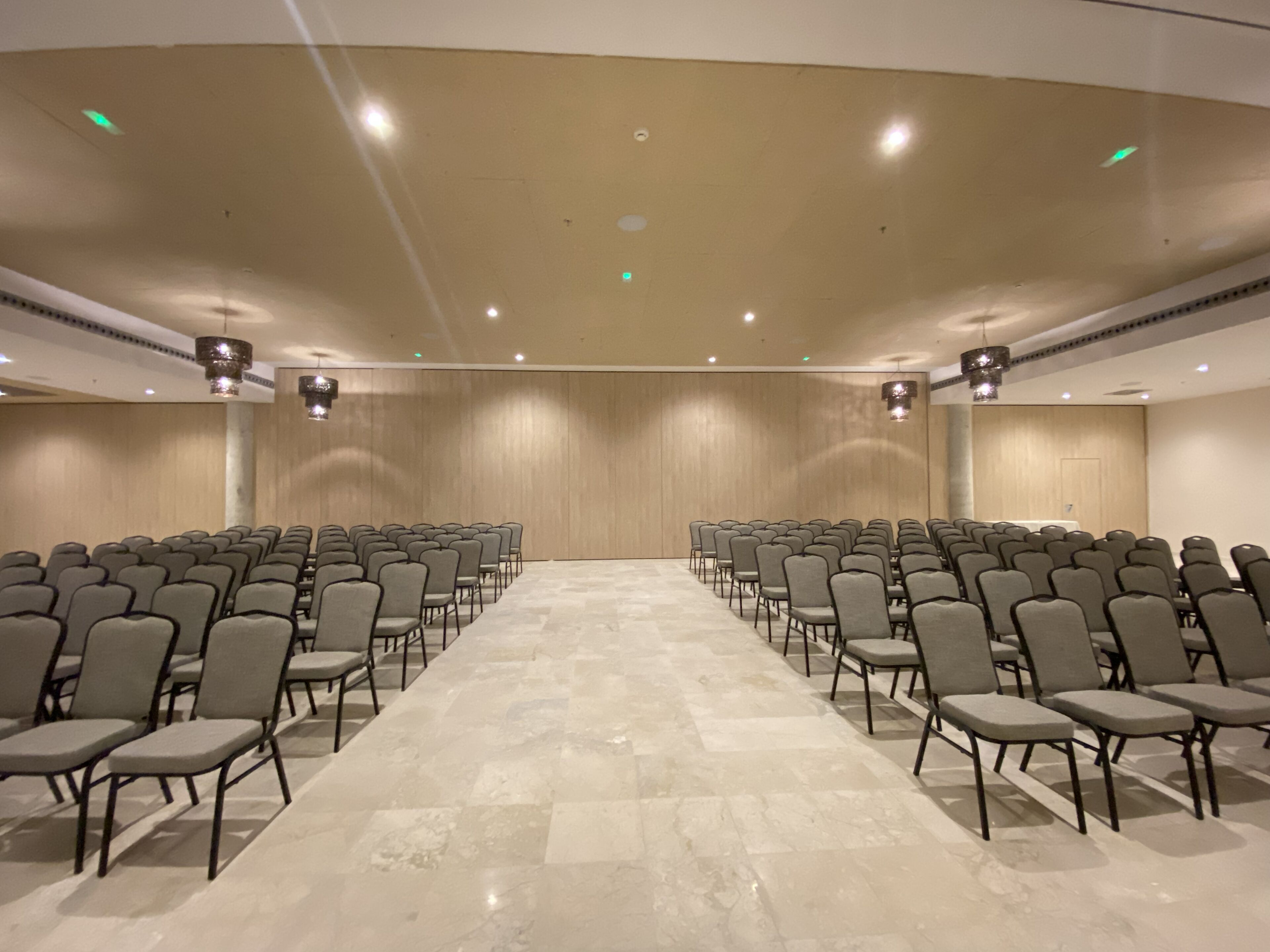 Een vergaderzaal met rijen stoelen gericht op een podium.