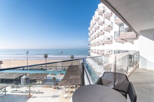 Un balcón con vista a la playa y la zona de la piscina.