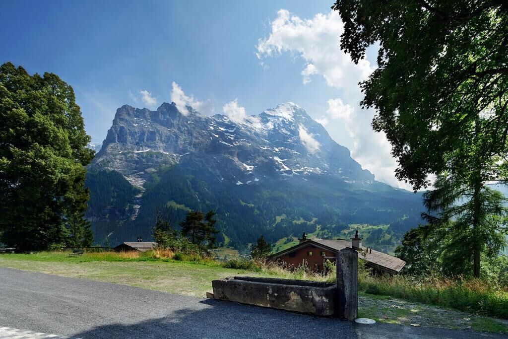 A mountain with a cabin in the foreground.