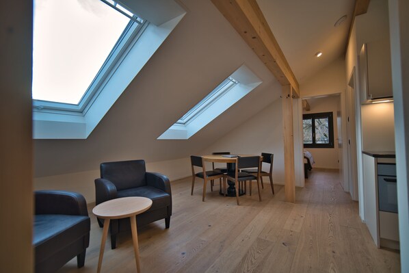Un loft moderno con tragaluces, comedor y cocina.