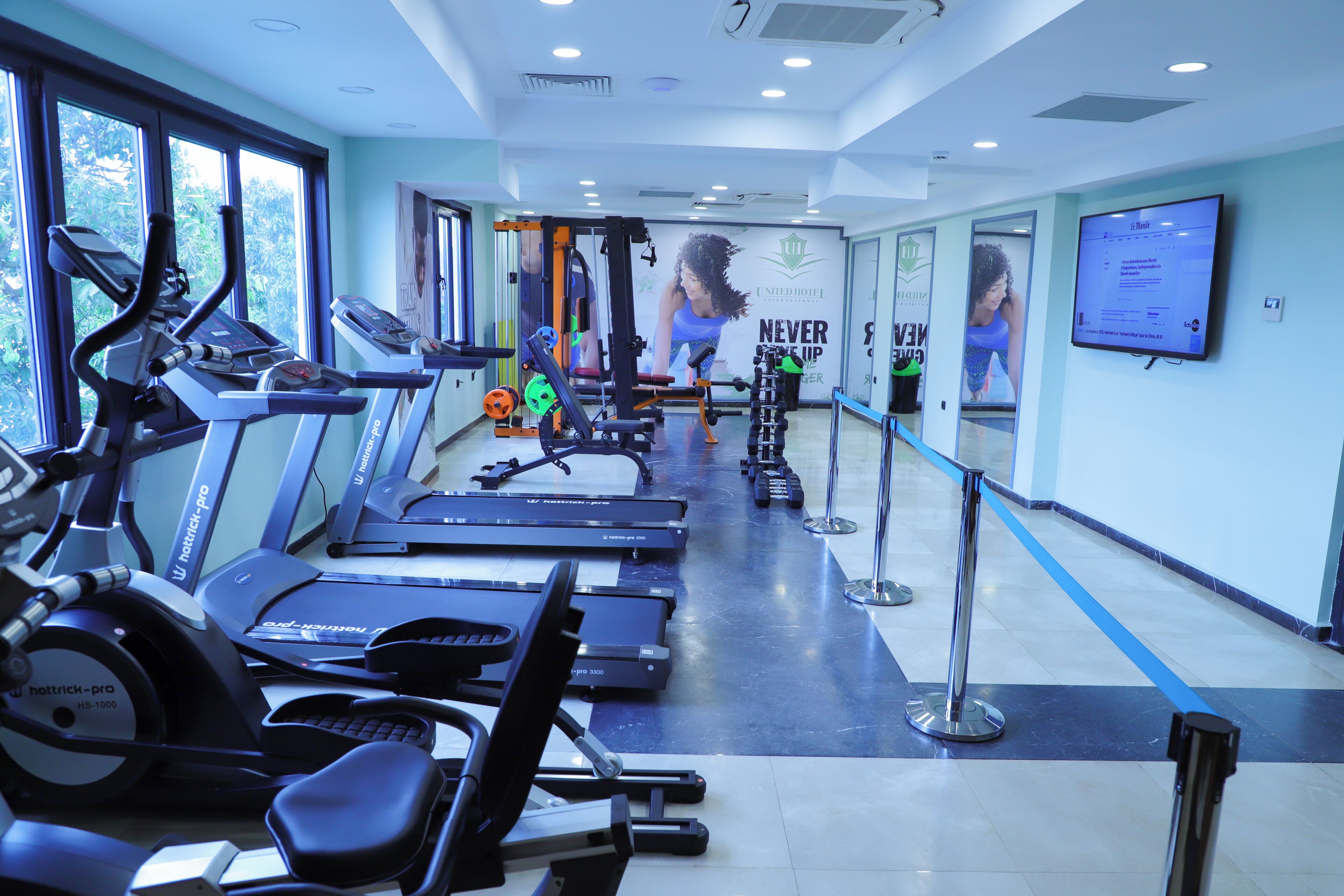 A gym with treadmills, elliptical machines, and weight equipment.