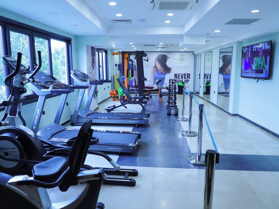 Un gimnasio con cintas de correr, elípticas y equipo de pesas.