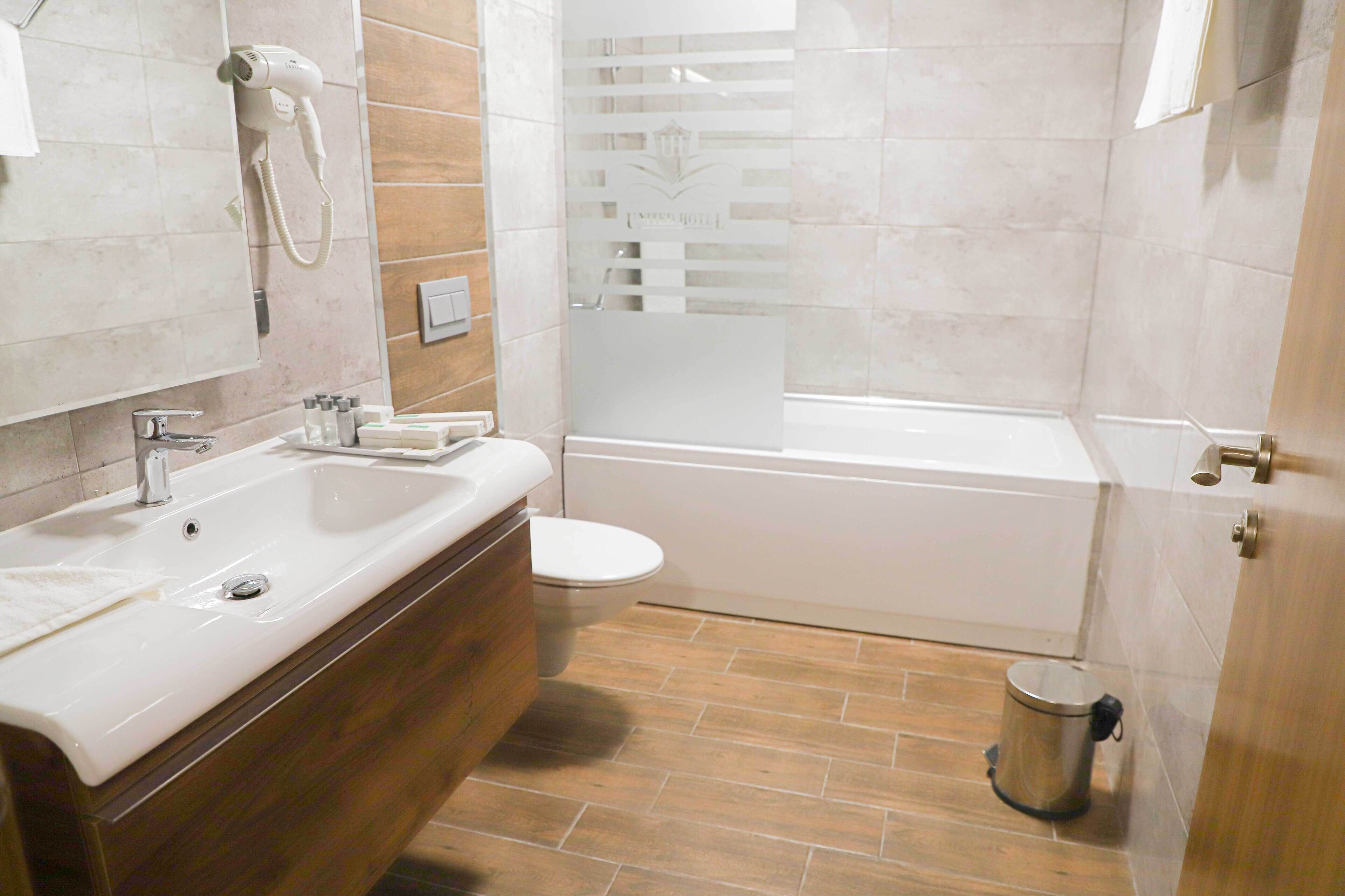 A bathroom with a sink, toilet, and shower.