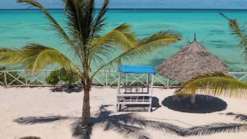 Plage privée, sable blanc, chaises longues, parasols