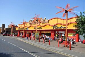 A casino with a prominent 'Golden Palm' sign, outdoor seating, and a visible entrance. - Captivating Three Bedroom Caravan tv in Each Room (Skegness)