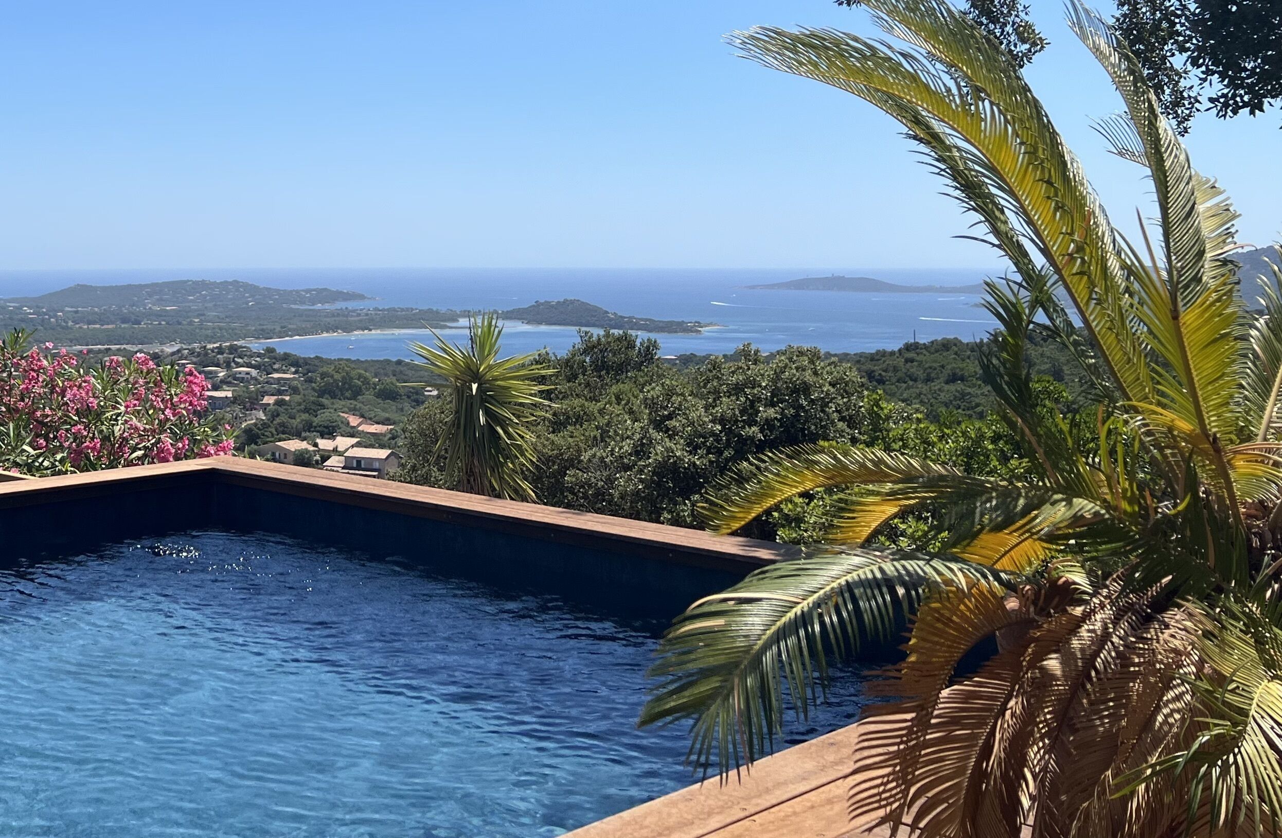 Une piscine avec vue sur la mer et les collines.