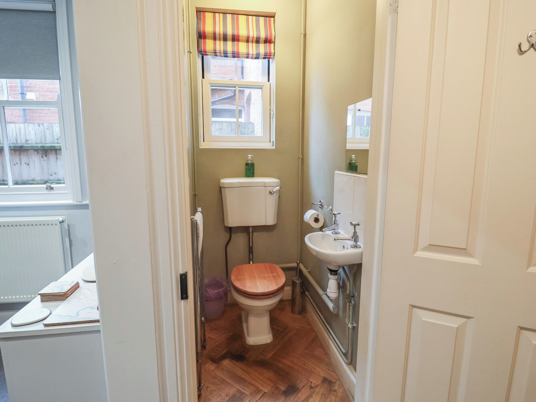 Ein kleines Badezimmer mit Toilette, Waschbecken und Fenster.