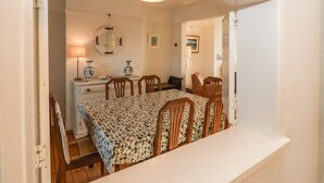 A room with a bed, a table, chairs, a dresser, and a mirror.