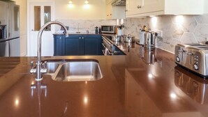 A modern kitchen with a stainless steel sink, a microwave, and a toaster. - Seadrift (Saxmundham)