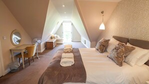 A bedroom with a large bed, a desk, a chair, and a small table. - Seadrift (Saxmundham)