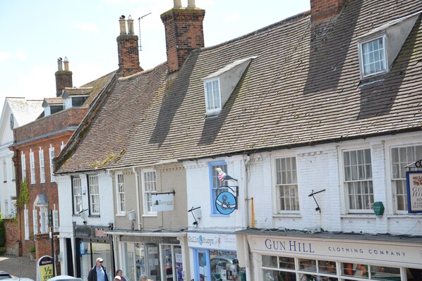 A row of traditional buildings with a clothing store named Gun Hill.